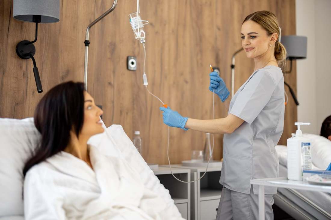 Nurse adjusting an IV hydration drip for a patient